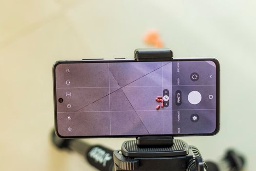 Close up shot of a phone on tripod capturing medicine on the surface