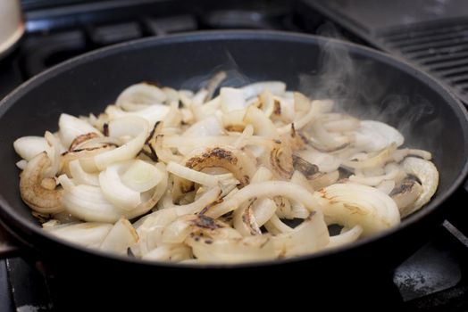 Diced onions sauteing in a frying pan to soften them ready to be added to a recipe as a cooking ingredient