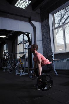 Vertical shot of a muscular sportsman doing deadlift exercise with barbell