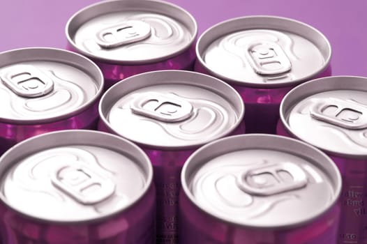 Close Up of Tops of Purple Soda Cans in Studio with Purple Background