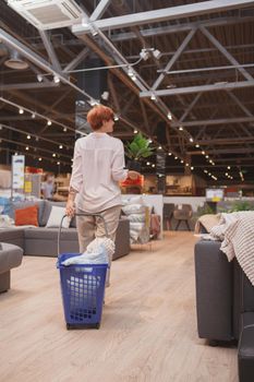 Vertical rear view shot of a female customer shopping at furniture store