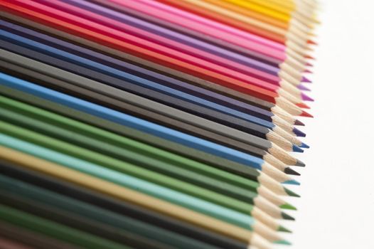 Close Up Still Life of Set of Colorful Pencil Crayons Arranged in Rainbow Spectrum on White Background with Copy Space - Art and Creativity Concept Image