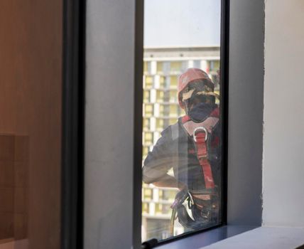 Silhouette of a rope access glass cleaner working at heights.