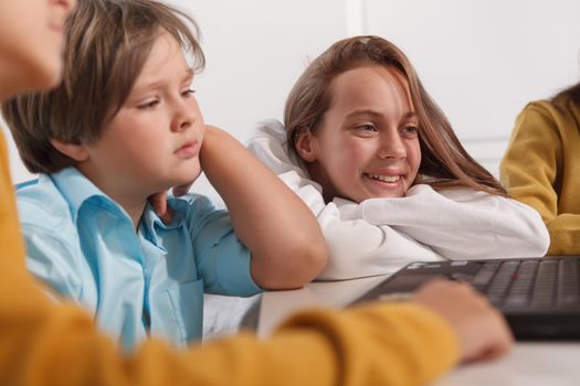 Cheerful teen schoolgirl smiling, studying with her classmates