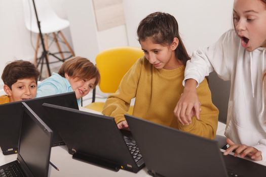 Diverse group of kids having fun, working together on a online project on their computers