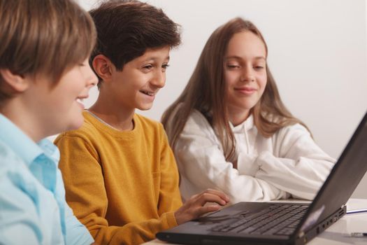 Group of happy kids having fun studying together at computer school