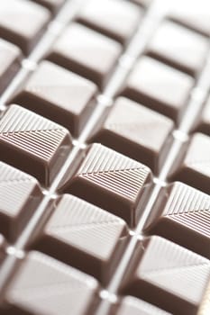 Selective focus close up with details in middle section on milk chocolate square sections