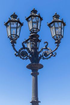 vintage street lamp on a blue sky background. photo