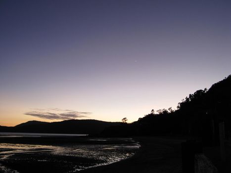 twilight after the sun has set leaving a silhouette of a coastal landscape