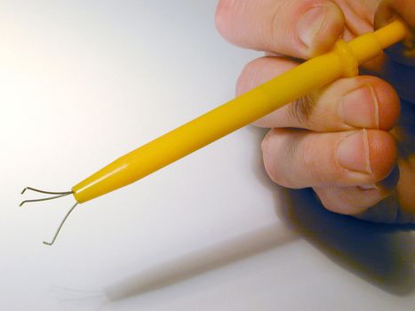 Using yellow plastic pearl grips tool, viewed in close-up on white background