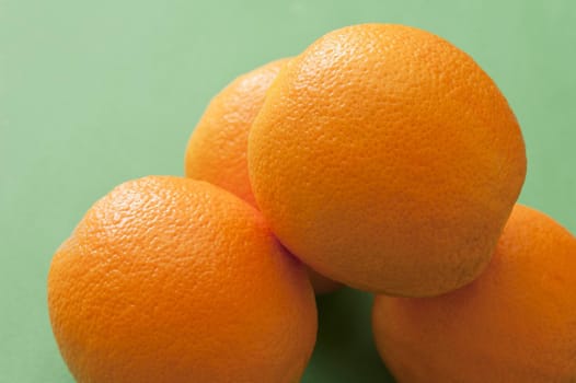 Close-up of several oranges on green background