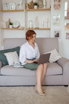 A business woman with a laptop. A human design specialist works at home on a laptop. Work from home during the epidemic.