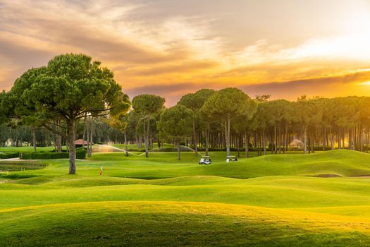 Golf course at sunset with beautiful sky. Scenic panoramic view of golf fairway