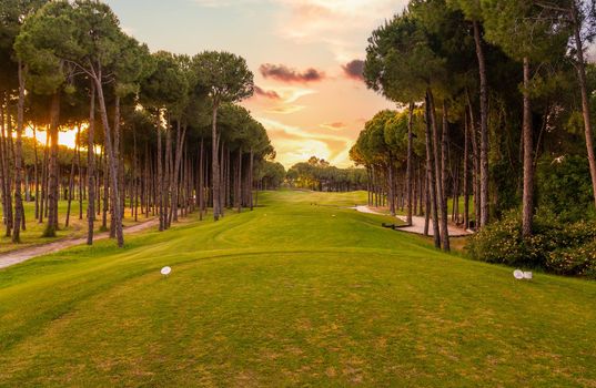 teeing area at Golf course at sunset with beautiful sky. Scenic panoramic view of golf fairway