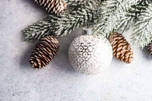 Christmas frame with pine tree, cones and ball on white rustic background