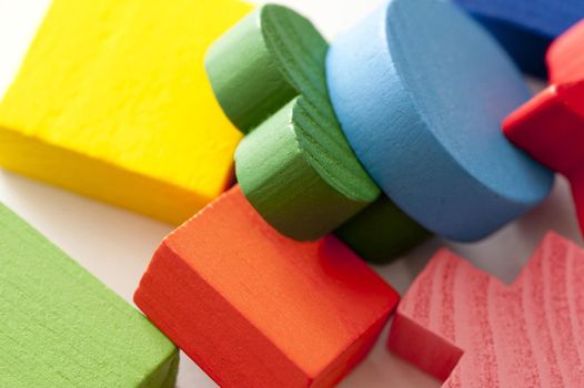 Colorful educational wooden toy blocks in assorted shapes for entertaining and teaching kids in a close up jumbled view