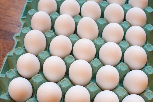 Cardboard tray of delicious farm fresh white hens eggs in a store or farmers market