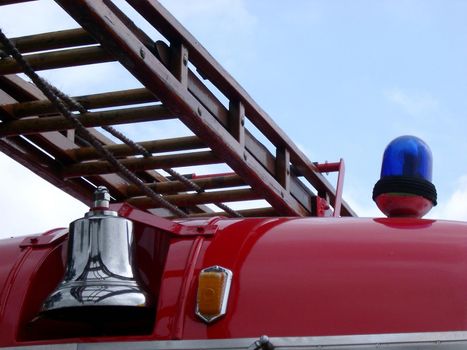 bell and ladder on the front of an old fashioned fire tender