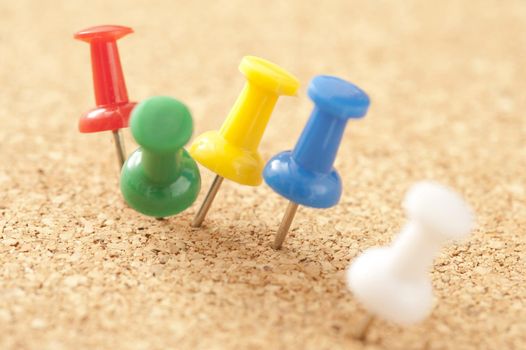 Close up Assorted Colors of Marker Tacks Pinned on Brown Cork Board