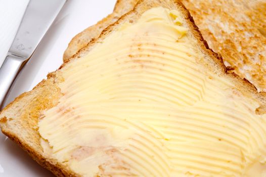 Closeup of a whole slice of buttered toast served for breakfast or as a midday snack