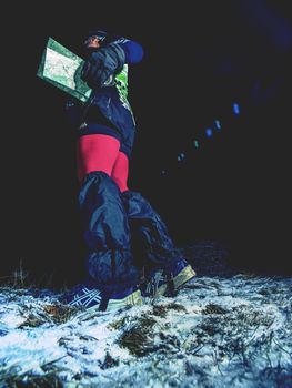 Female runner reading map and check possition, Orienteering cup race.  January 25th 2019, Novy Bor, Czech Republic. Competitor reading map while resting. Racer looking for direction guide. 