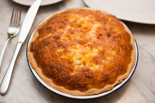 Delicious golden freshly baked uncut pie on a dinner table waiting to be carved and served
