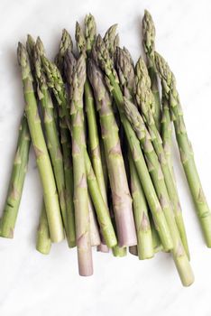 A bunch of fresh green asparagus on white background viewed from above