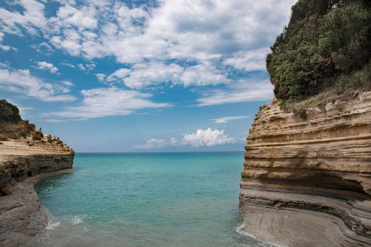 the concept of recreation and wellness for children and adults to breathe the sea air, take natural vitamin D from the sun lying under the blue sky or making a water voyage on a boat or a speedboat to enjoy the splash of waves and catch the magical shades of water in Paleokastritsa on the island of Corfu Corfu in Greece. High quality photo