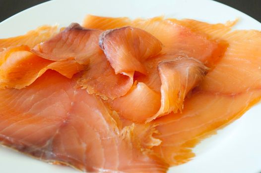 Dish of thinly sliced gourmet smoked salmon for a gourmet appetizer or seafood meal