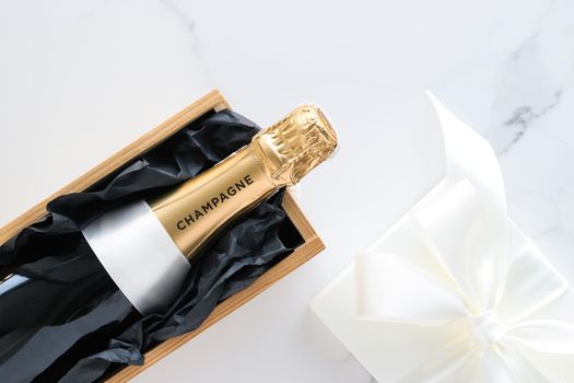 Wedding celebration, lifestyle and luxury present concept - A champagne bottle and a gift box on marble