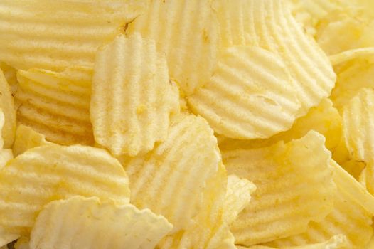 Delicious plain ruffled potato chips piled unceremoniously one atop another