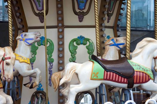 Colorful decorative horses on a carousel or merry-go-round at an amusement park in a close up view