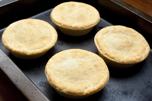 Close up Four Freshly Cooked Delicious Homemade Pies on a Black Tray for Snacks