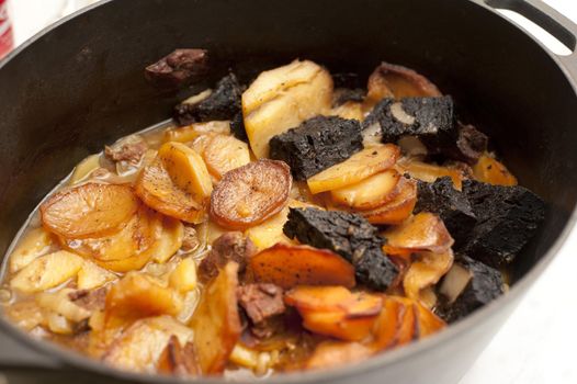 Hot pot stew made from lamb, black pudding and potatoes cooked in a sealed casserole dish, viewed high angle close up with the lid off