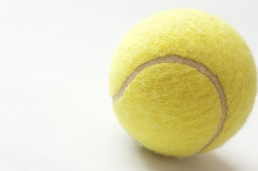 Close Up of Yellow Tennis Ball Showing Texture on White Background with Copyspace on Right Side
