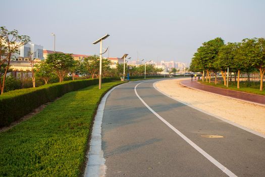 Jogging and cycling tracks in Al Warqa park, Dubai, UAE early in the morning. Lamp post powered by solar panels can be seen in the picture. Outdoors