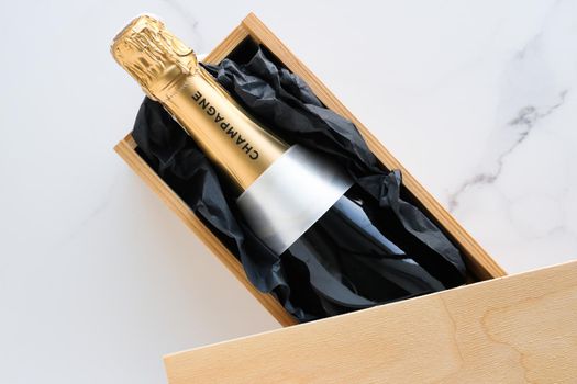 Wedding celebration, lifestyle and luxury present concept - A champagne bottle and a gift box on marble