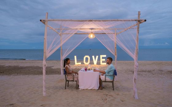 Romantic dinner on the beach of Huahin Thailand, dinner by candlelight in Hua Hin, Valentine's concept. Couple of men and women having a romantic dinner on the beach in Thailand