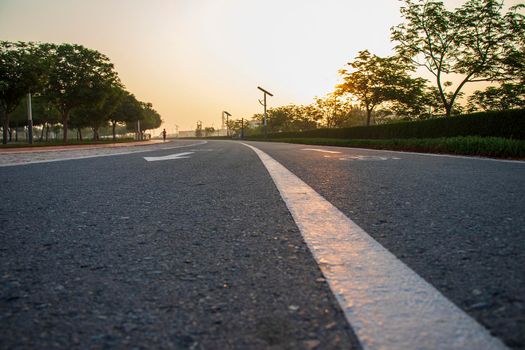 Jogging and cycling tracks in Al Warqa park, Dubai, UAE early in the morning. Lamp post powered by solar panels can be seen in the picture as well as minaret of a mosque. Outdoors