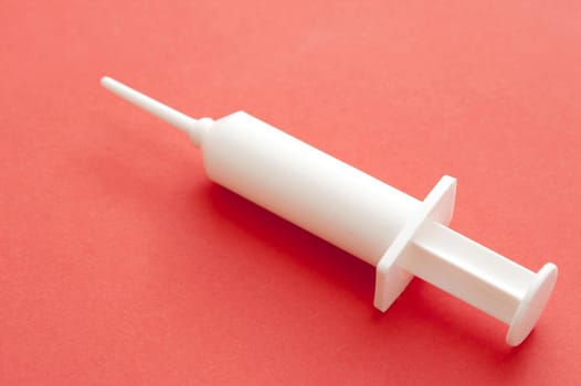 Vaccination Concept - Close up White Plastic Syringe on Pink Background, Isolated on Pink Background, Emphasizing Copy Space.