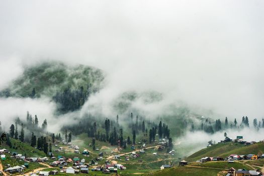 Traditional old wooden houses of Bakhmaro resort in georgian region Guria in foggy morning