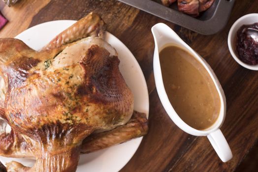 Roast Christmas or Thanksgiving turkey and gravy served on a table ready to be carved for a festive holiday celebration