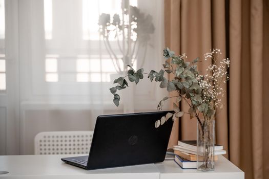 White desktop with laptop for remote work or study. Office computer workplace in home interior.