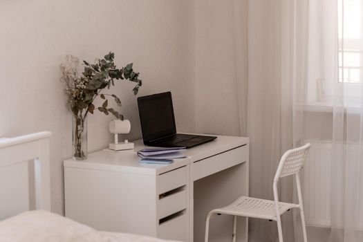 White desktop with laptop for remote work or study. Office computer workplace in home interior.