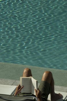 a nice way to relax - reading a book by the pool side