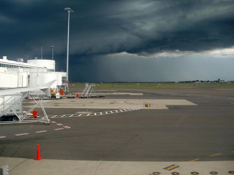 a menacing looking storm cloud over an airport runway