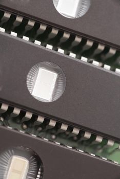 Close up of three memory chips, lined up side by side as components on a computer motherboard.