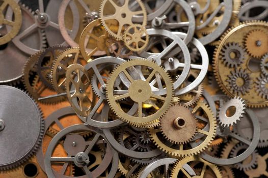 an array of metal gear cogs and components from a clockmakers parts bin