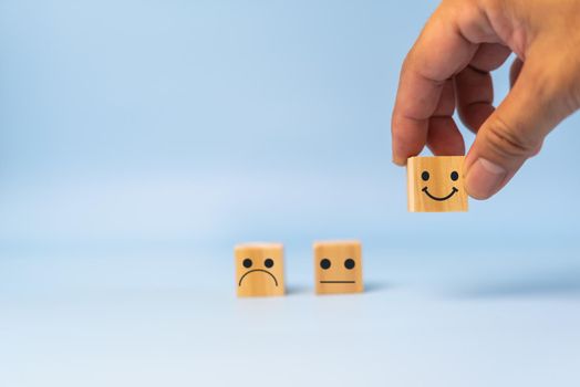 Customer service and Satisfaction concept happy Smiley face icon.Business feedback positive rating very impressed wood cube on table.