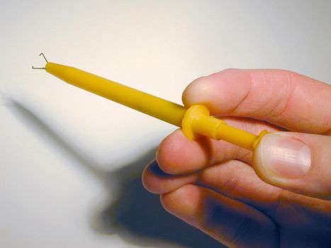 Man holding a set of pearl grips with extendable metal prongs for grasping gemstones and pearls